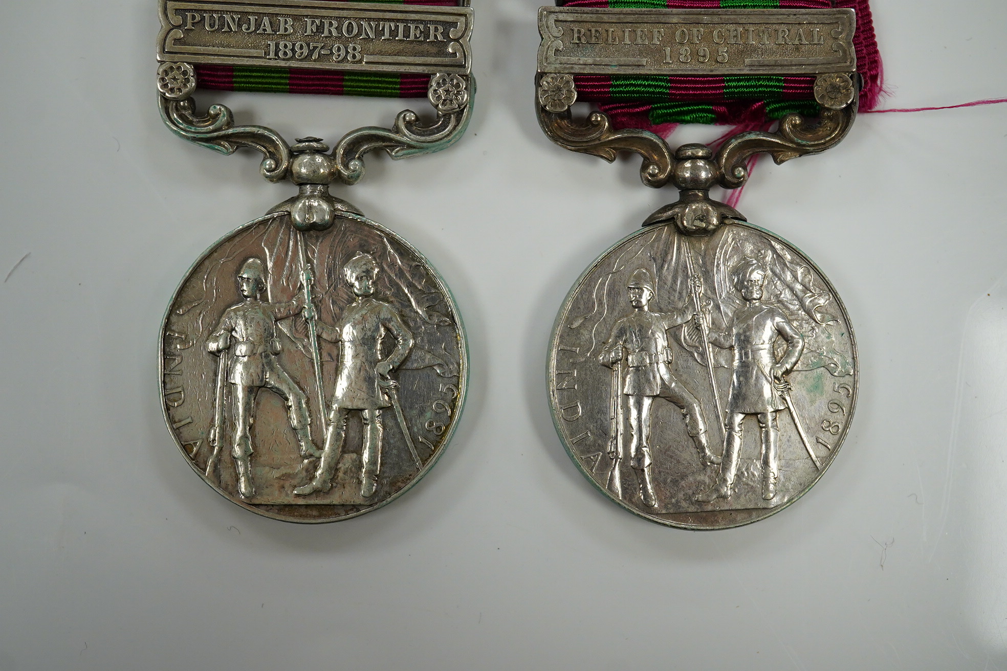 Two India Medals; one with Punjab Frontier 1897-98 and Relief of Chitral 1895 clasps, the other Tirah 1897-98 and Punjab Frontier 1897-98, both with naming erased.